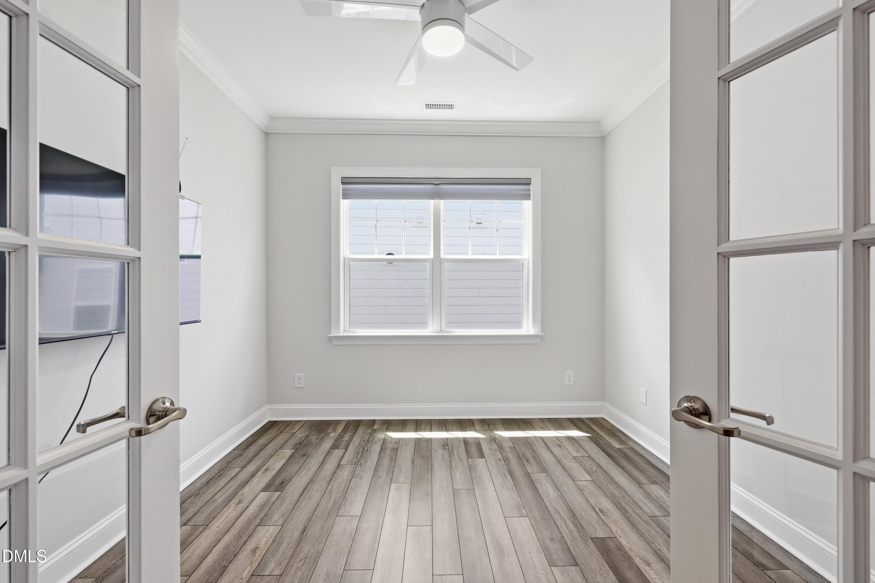 289 English Violet Lane Raleigh, NC 27610 - Photo 8 of 40 a view of empty room with wooden floor and fan