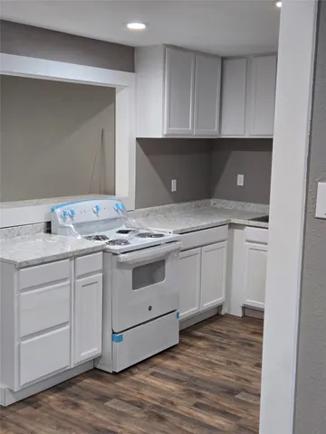 a kitchen with granite countertop white cabinets and white appliances