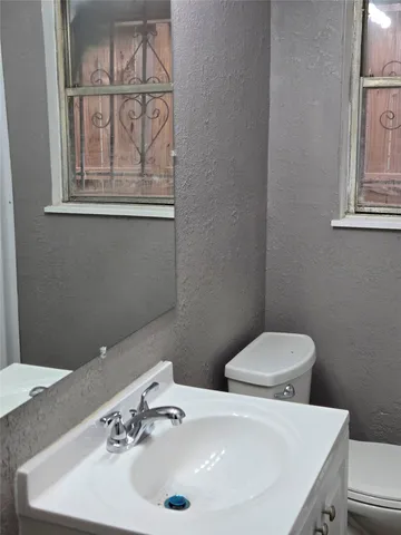 a bathroom with a sink a toilet and a mirror