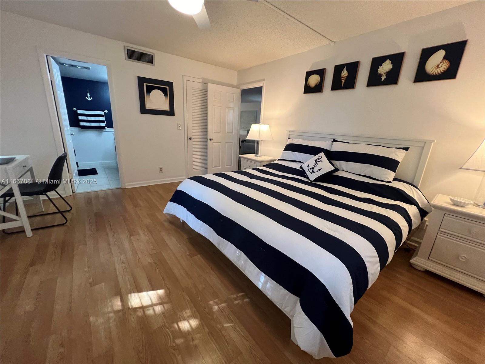 1280 Surf Road, Unit 103 Singer Island, FL 33404 - Photo 11 of 55 a bedroom with a bed and painting on the wall