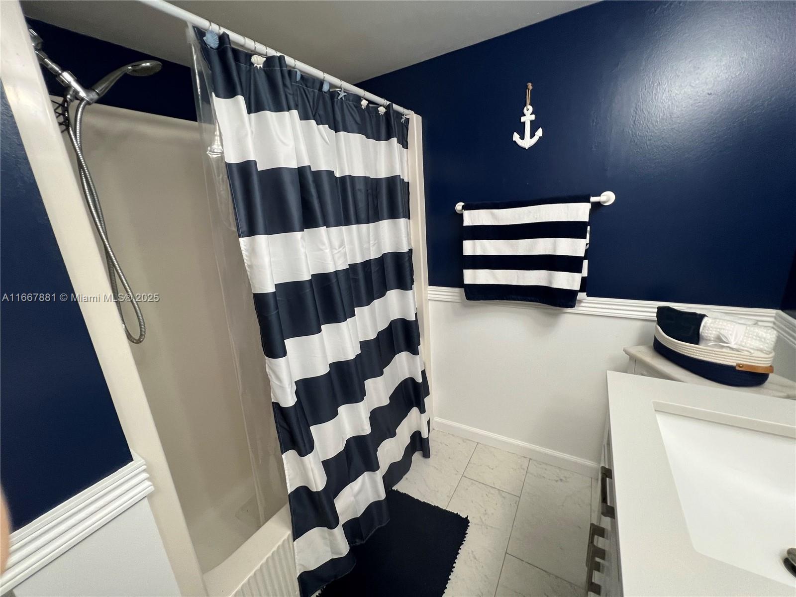 1280 Surf Road, Unit 103 Singer Island, FL 33404 - Photo 13 of 55 a bathroom with a sink a toilet a shower and a mirror