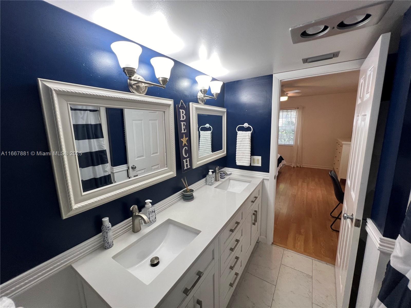 1280 Surf Road, Unit 103 Singer Island, FL 33404 - Photo 14 of 55 a bathroom with a sink vanity and mirror