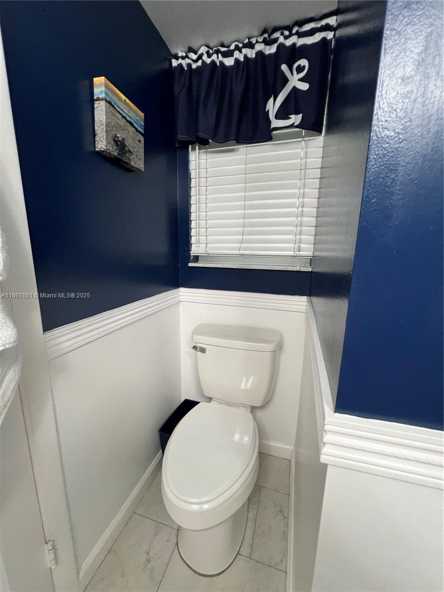 1280 Surf Road, Unit 103 Singer Island, FL 33404 - Photo 16 of 55 a white toilet sitting next to a shower