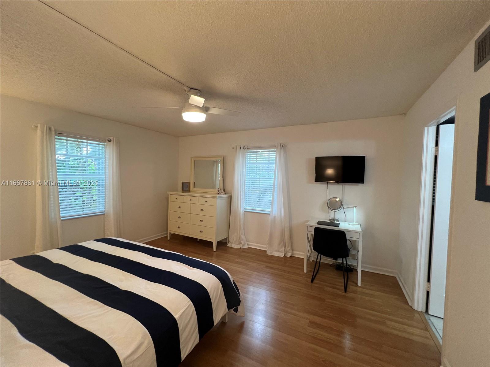 1280 Surf Road, Unit 103 Singer Island, FL 33404 - Photo 18 of 55 a bedroom with a bed and a flat screen tv