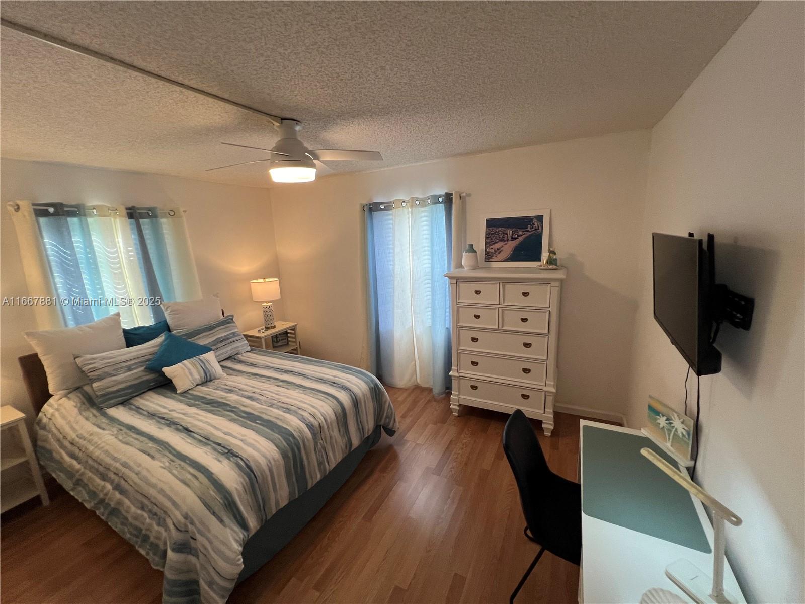 1280 Surf Road, Unit 103 Singer Island, FL 33404 - Photo 19 of 55 a bedroom with a bed and a flat screen tv