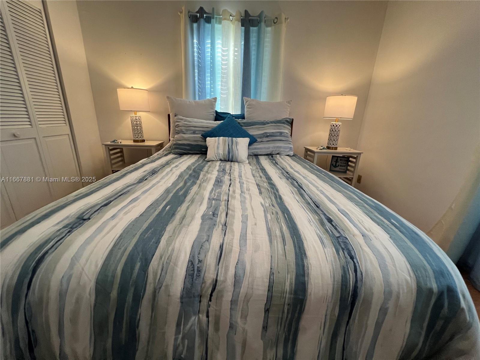 1280 Surf Road, Unit 103 Singer Island, FL 33404 - Photo 20 of 55 a bed room with a bed and a lamp