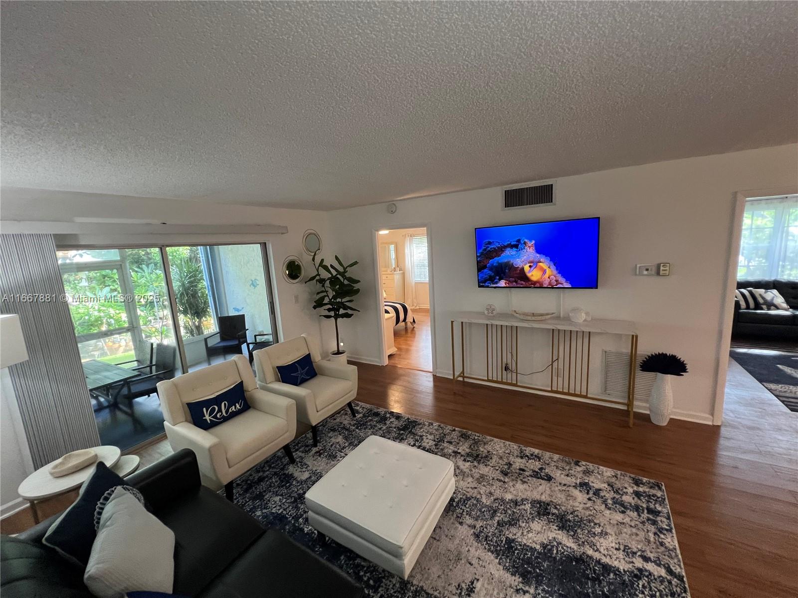 1280 Surf Road, Unit 103 Singer Island, FL 33404 - Photo 2 of 55 a living room with furniture rug and wooden floor