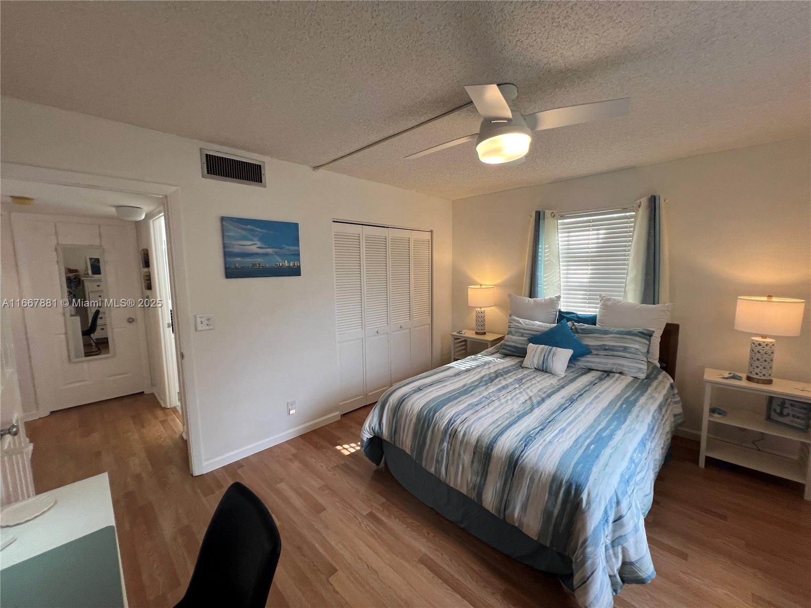 1280 Surf Road, Unit 103 Singer Island, FL 33404 - Photo 21 of 55 a bedroom with a bed and a chandelier