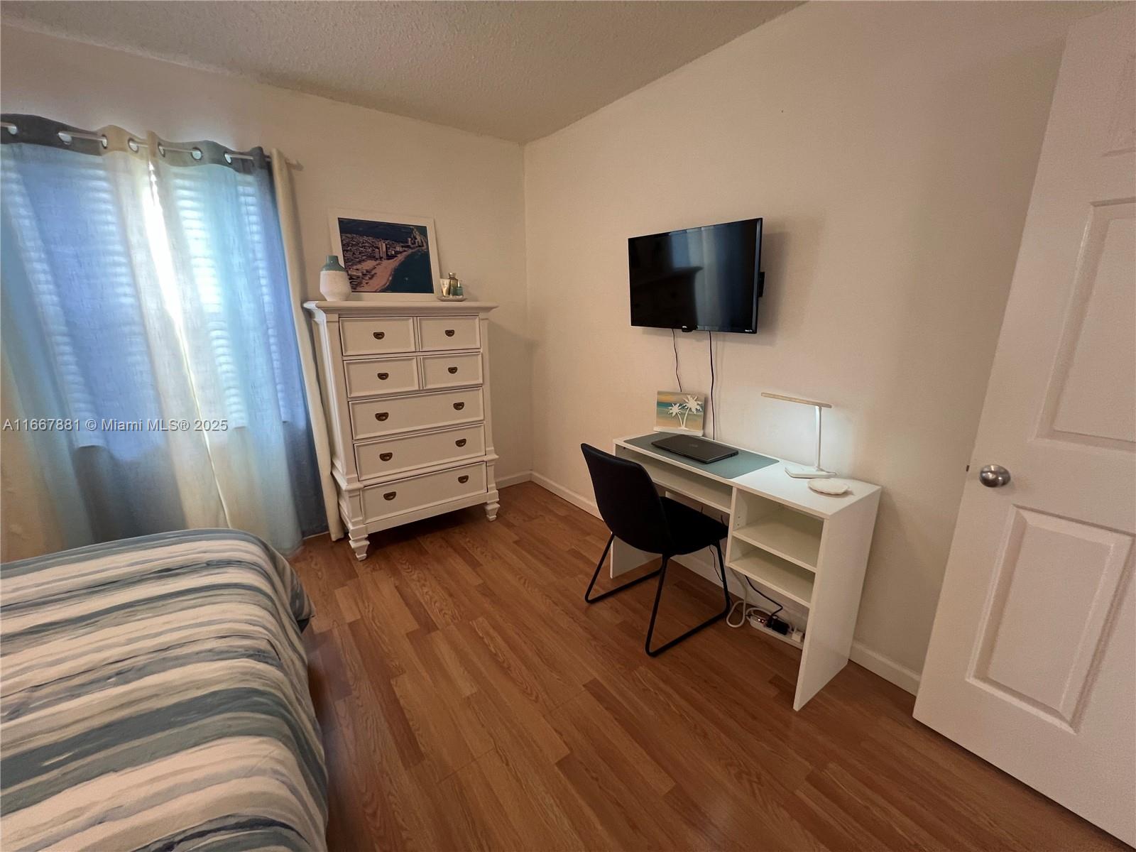 1280 Surf Road, Unit 103 Singer Island, FL 33404 - Photo 22 of 55 a bedroom with a bed and a flat screen tv