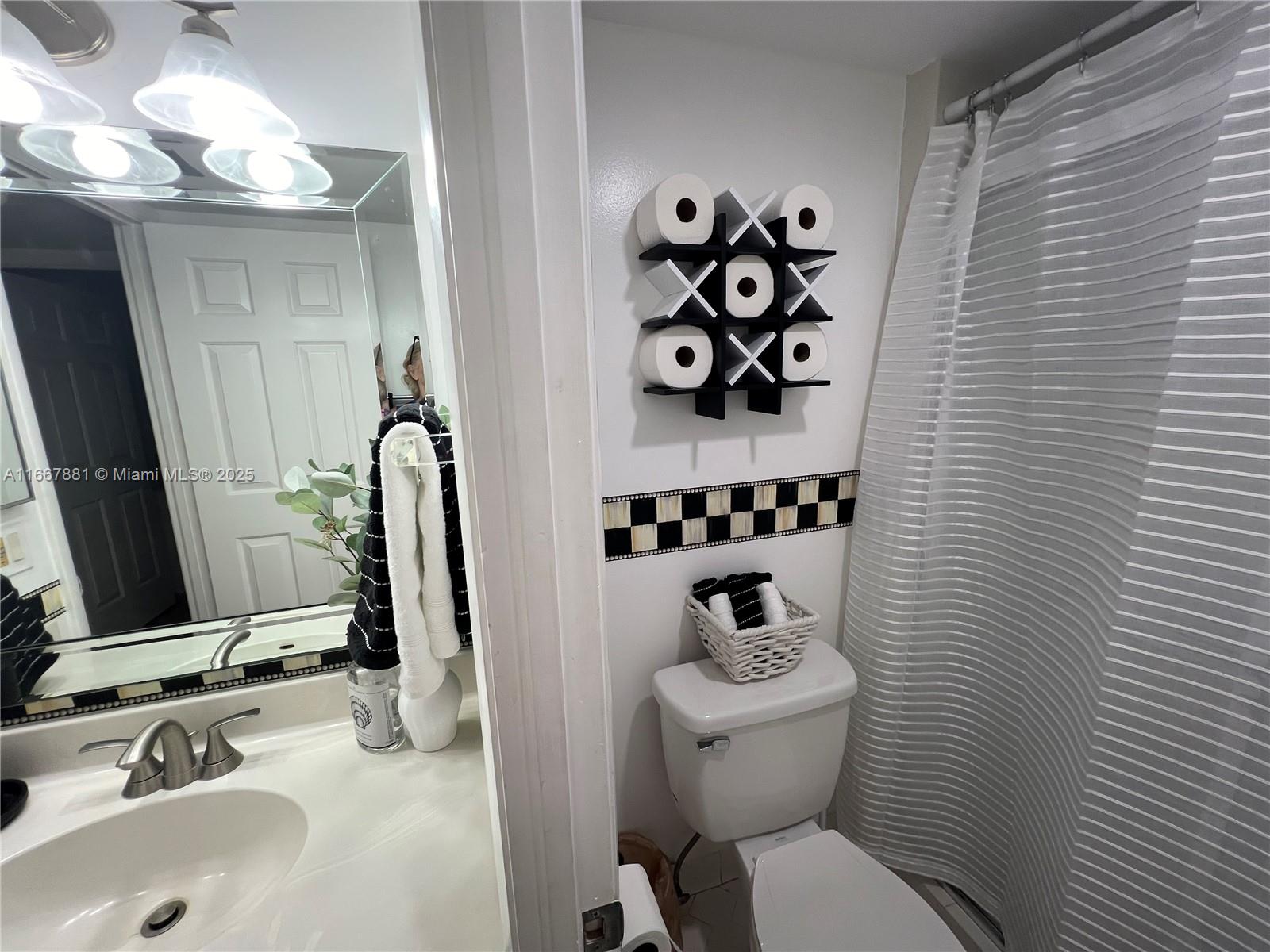 1280 Surf Road, Unit 103 Singer Island, FL 33404 - Photo 25 of 55 a bathroom with a toilet sink and mirror