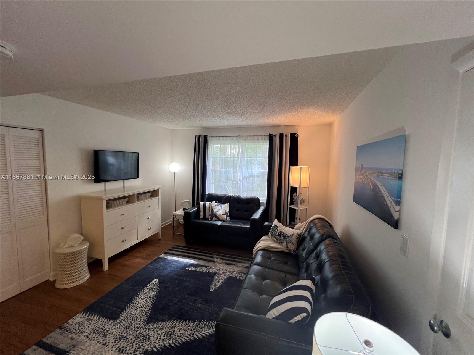 1280 Surf Road, Unit 103 Singer Island, FL 33404 - Photo 28 of 55 a living room with furniture and a flat screen tv