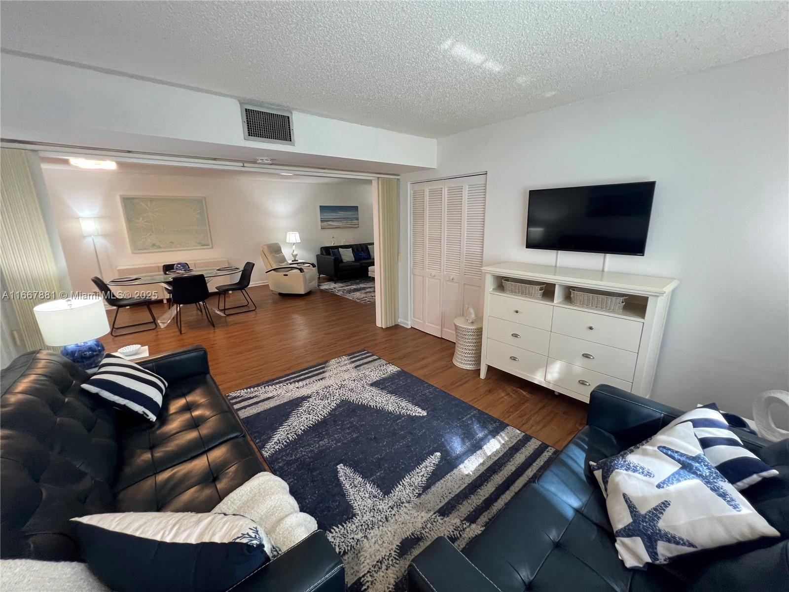 1280 Surf Road, Unit 103 Singer Island, FL 33404 - Photo 29 of 55 a living room with furniture and a flat screen tv