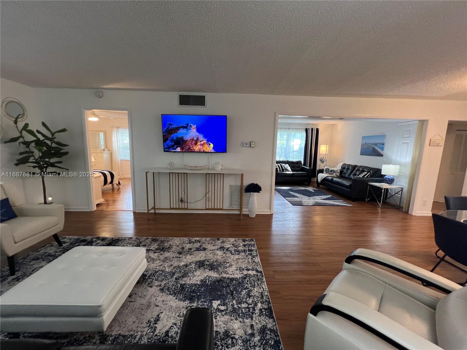 1280 Surf Road, Unit 103 Singer Island, FL 33404 - Photo 42 of 55 a living room with furniture and a flat screen tv
