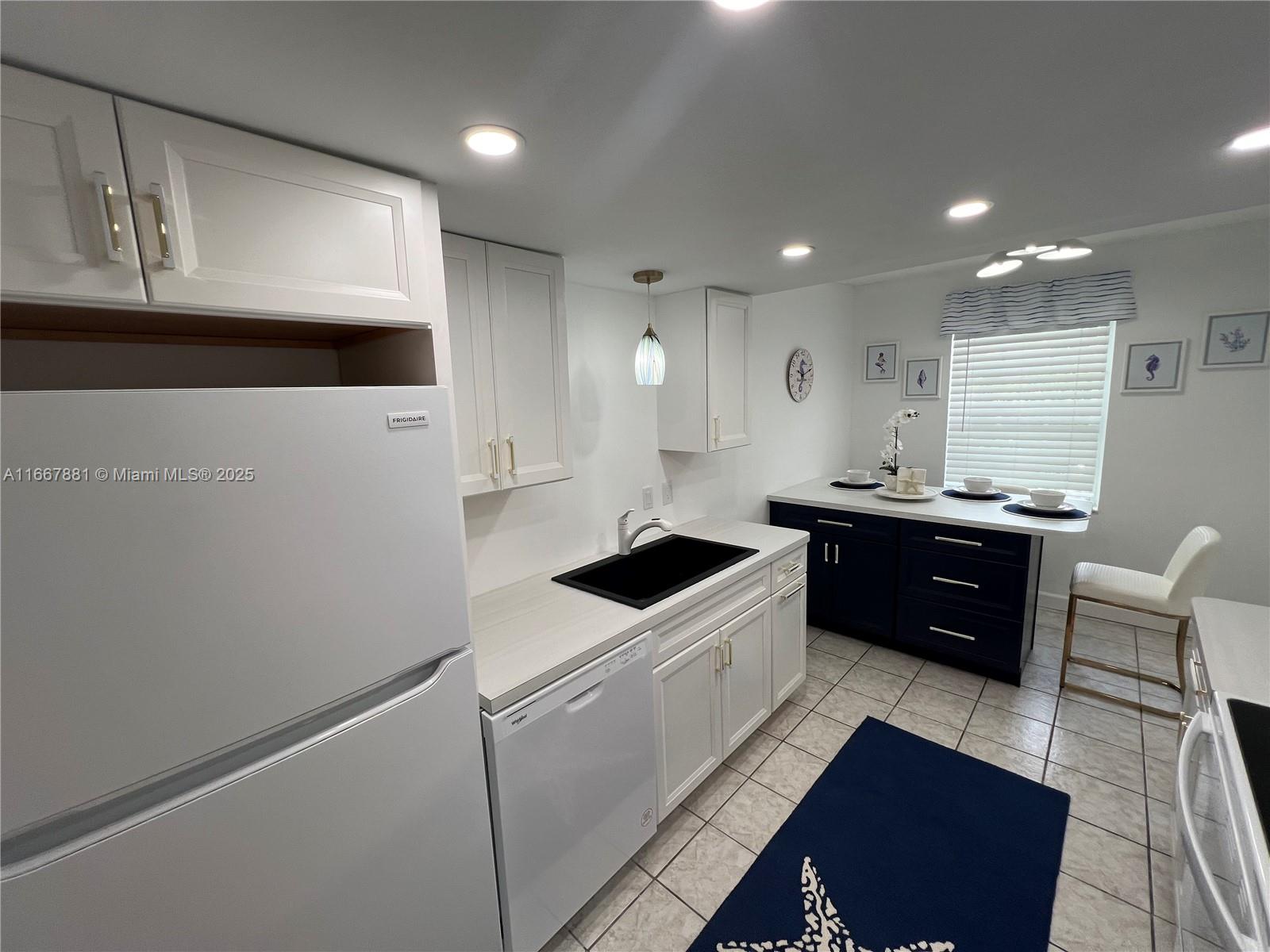 1280 Surf Road, Unit 103 Singer Island, FL 33404 - Photo 6 of 55 a kitchen with stainless steel appliances a sink a stove a refrigerator and a refrigerator with wooden floor