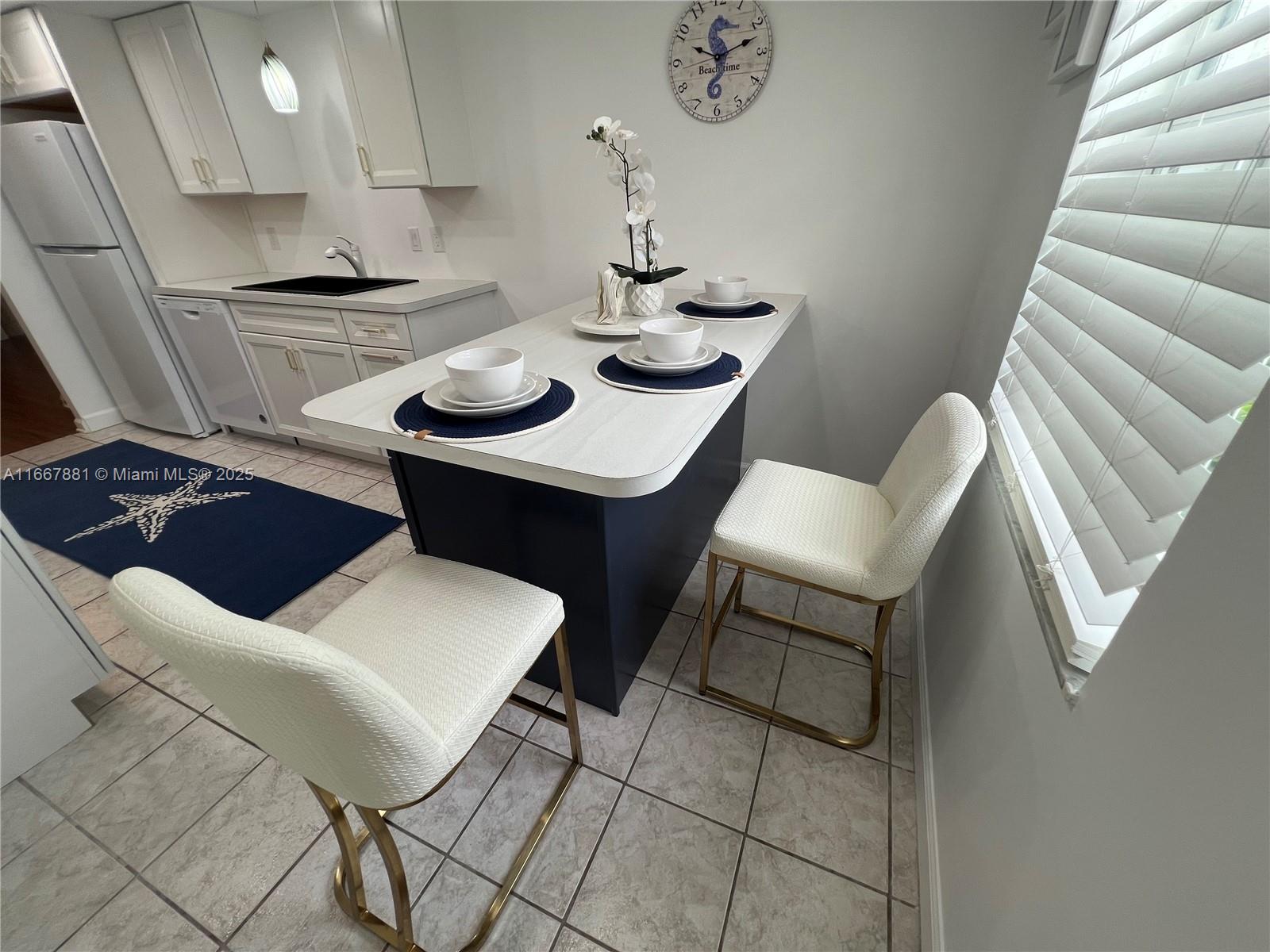 1280 Surf Road, Unit 103 Singer Island, FL 33404 - Photo 7 of 55 a kitchen with a table and chairs in it