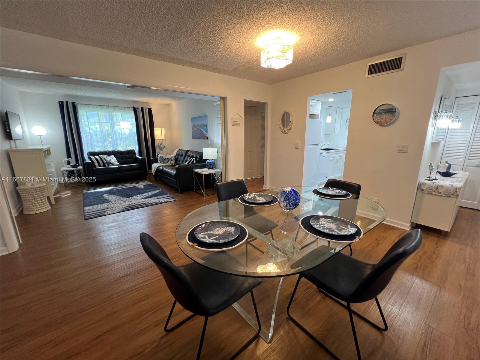 1280 Surf Road, Unit 103 Singer Island, FL 33404 - Photo 9 of 55 a view of a dining room with furniture and wooden floor