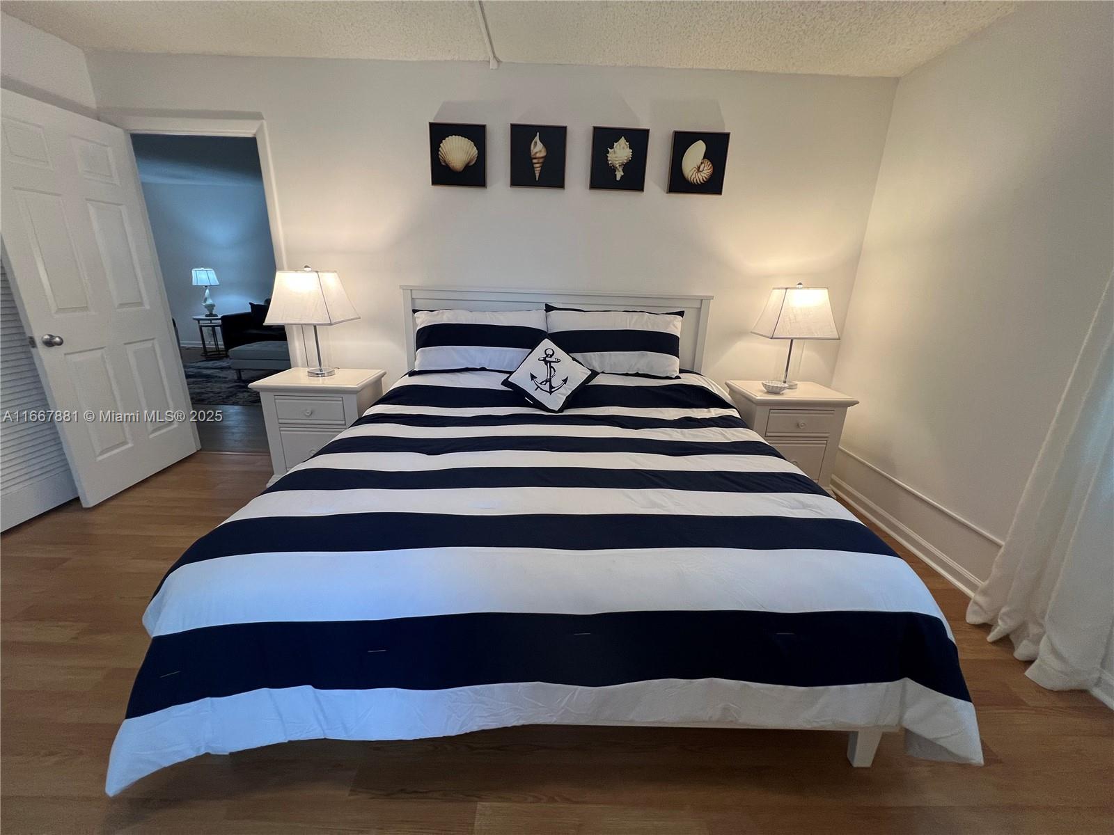 1280 Surf Road, Unit 103 Singer Island, FL 33404 - Photo 10 of 55 a bedroom with a bed and wooden floor