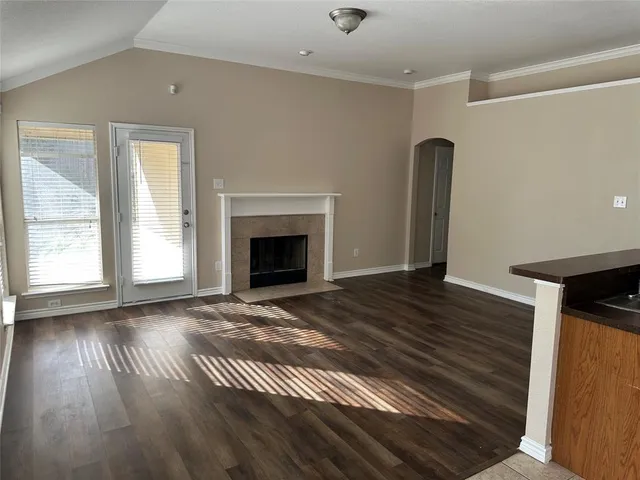 a view of empty room with wooden floor and fireplace