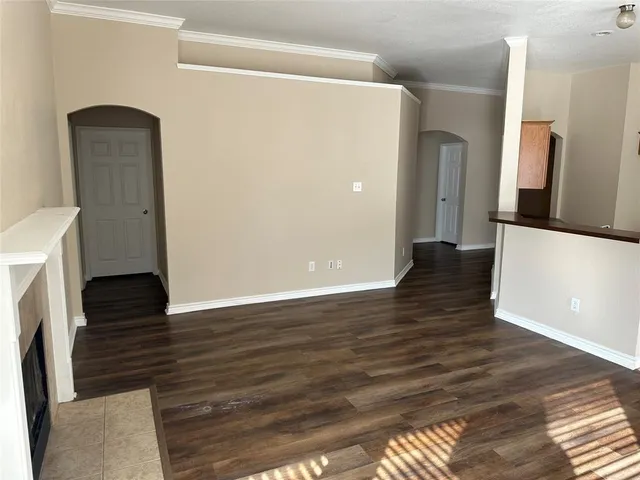 a view of a livingroom with wooden floor and a refrigerator