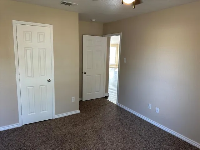 an empty room with windows and closet