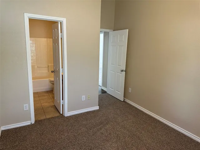 an empty room with windows and lamp