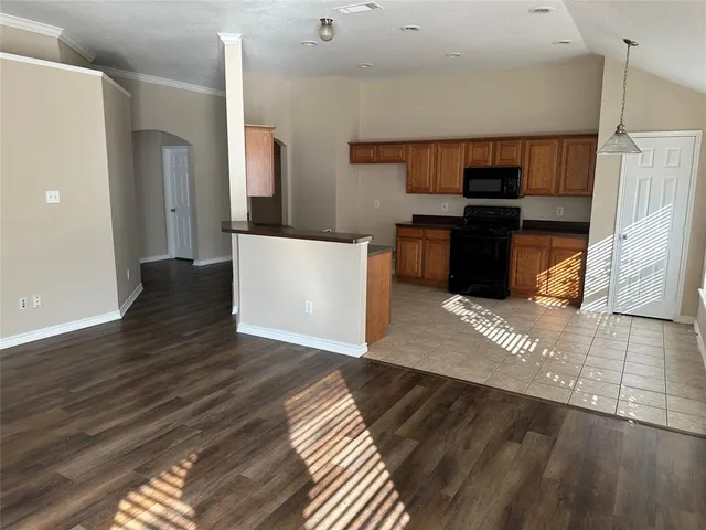 a view of a kitchen with wooden floor and electronic appliances