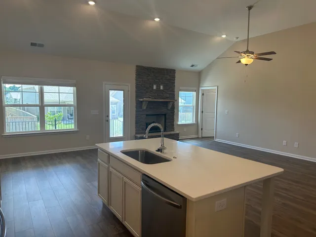a kitchen that has a sink a oven and a window with wooden floor