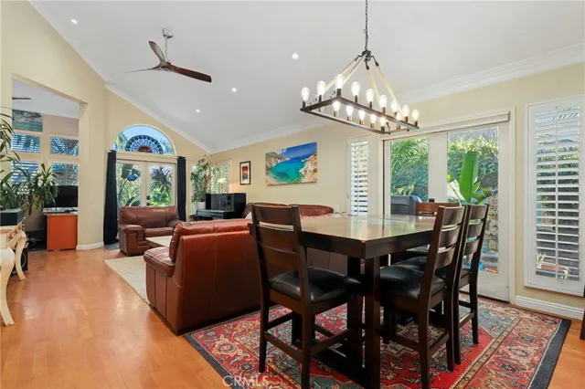 a view of a dining room with furniture a chandelier and wooden floor