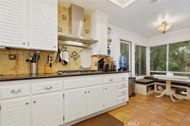 a kitchen with granite countertop a sink and white cabinets