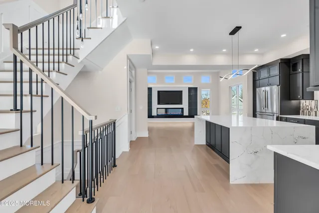 a large kitchen with stainless steel appliances a large counter top a stove and a sink