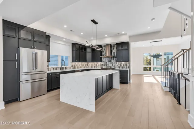 an empty room with wooden floor fireplace and windows