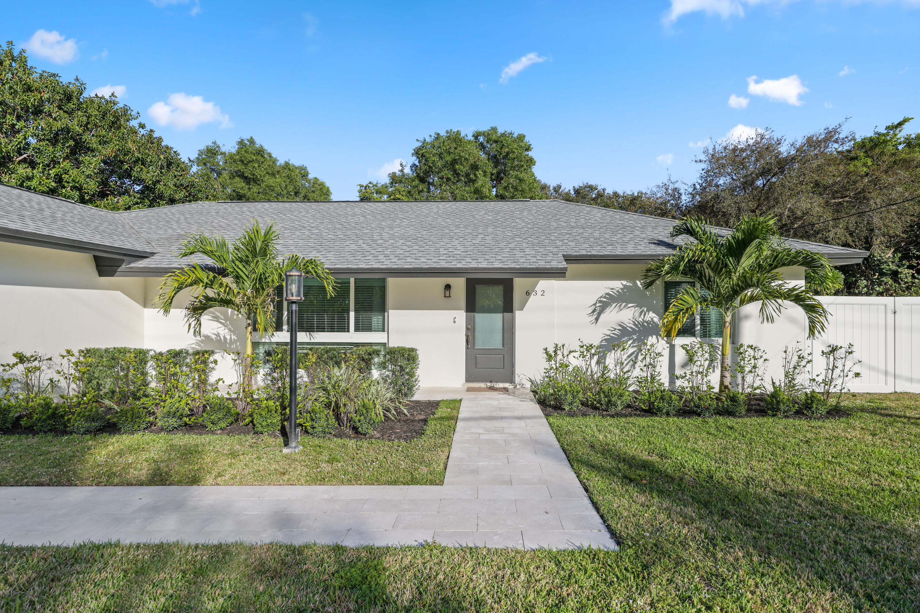 632 East Conference Drive Boca Raton, FL 33486 - Photo 1 of 49 a front view of a house with garden