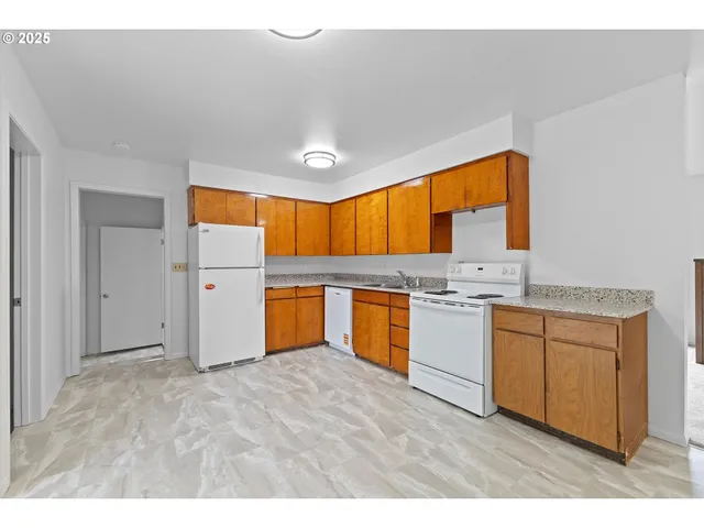 a kitchen with granite countertop a sink stainless steel appliances and cabinets