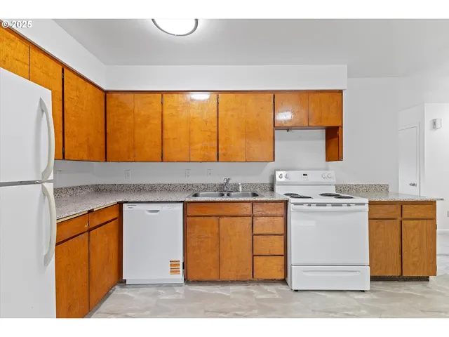 a kitchen with stainless steel appliances granite countertop a stove a sink and a refrigerator