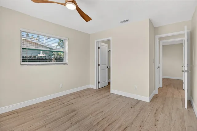 a view of an empty room with wooden floor