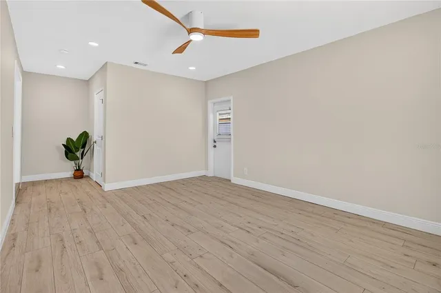 a view of an empty room with wooden floor