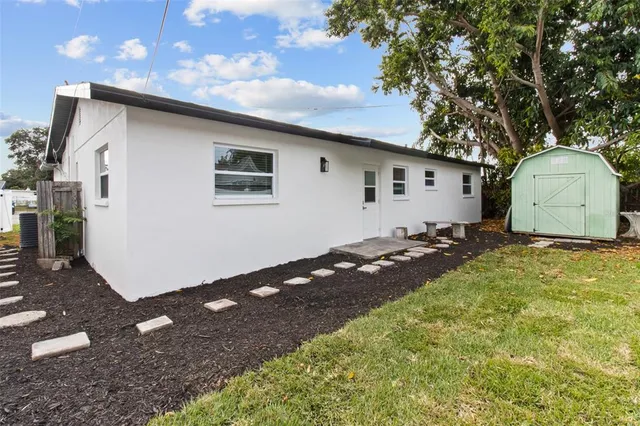 a backyard of a house with wooden fence and a tree