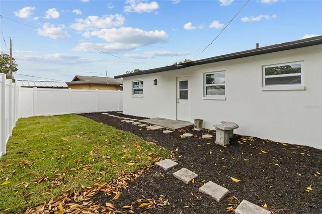a backyard of a house with table and chairs