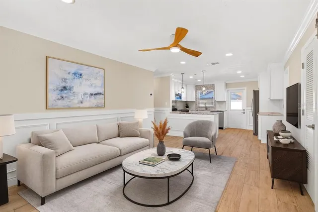 a living room with furniture and a flat screen tv with kitchen view