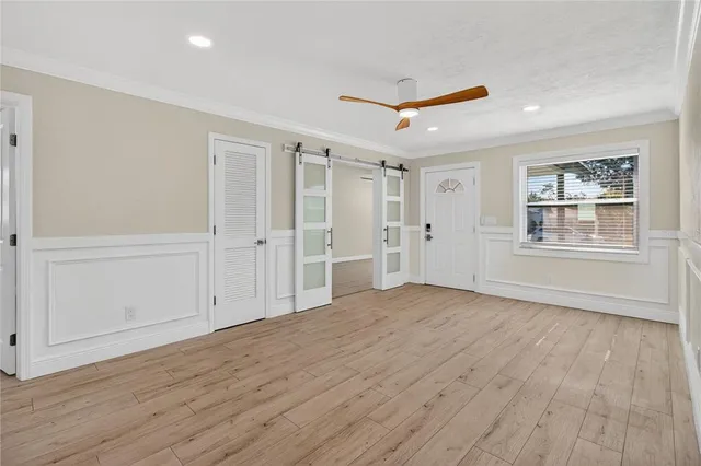 a view of empty room with wooden floor and window
