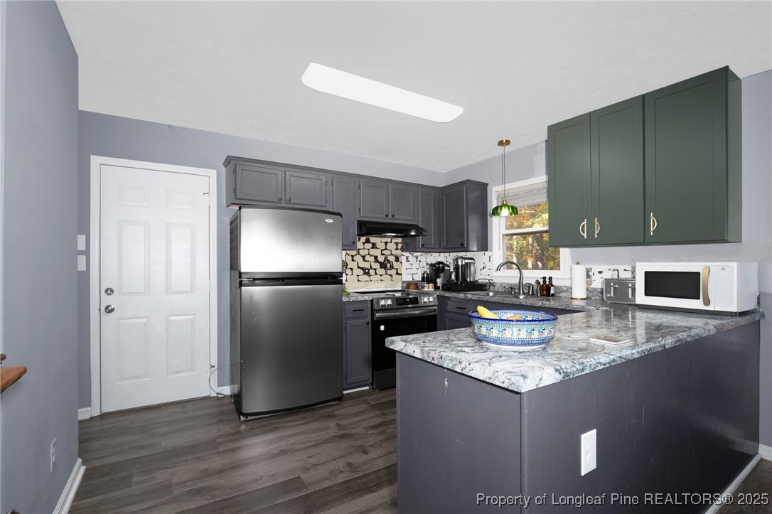 529 Old Farm Road Fayetteville, NC 28314 - Photo 13 of 35 a kitchen with a refrigerator a microwave a sink and cabinets