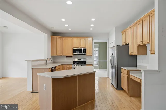a large kitchen with stainless steel appliances lots of white cabinets