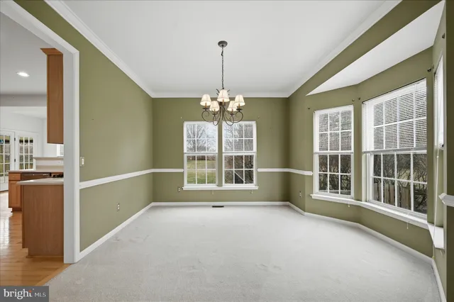 a view of a livingroom with a chandelier fan and windows