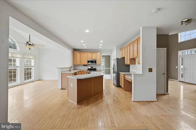 a kitchen with a sink a counter top space stainless steel appliances and cabinets
