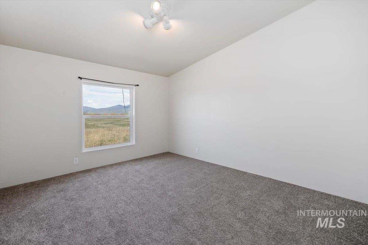 501 Timber Avenue Fairfield, ID 83327 - Photo 17 of 27 Spare room with carpet floors and vaulted ceiling