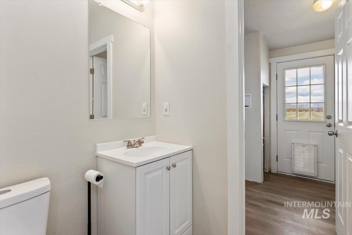501 Timber Avenue Fairfield, ID 83327 - Photo 18 of 27 Half bathroom featuring vanity, a textured wall, and dark wood-type flooring