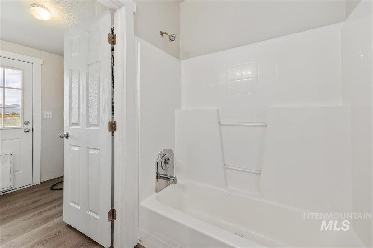 501 Timber Avenue Fairfield, ID 83327 - Photo 19 of 27 Bathroom featuring shower combination and light wood finished floors