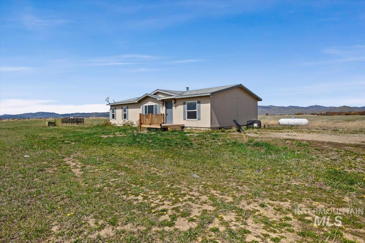 501 Timber Avenue Fairfield, ID 83327 - Photo 2 of 27 View of front facade featuring a mountain view, a view of countryside, and a front lawn