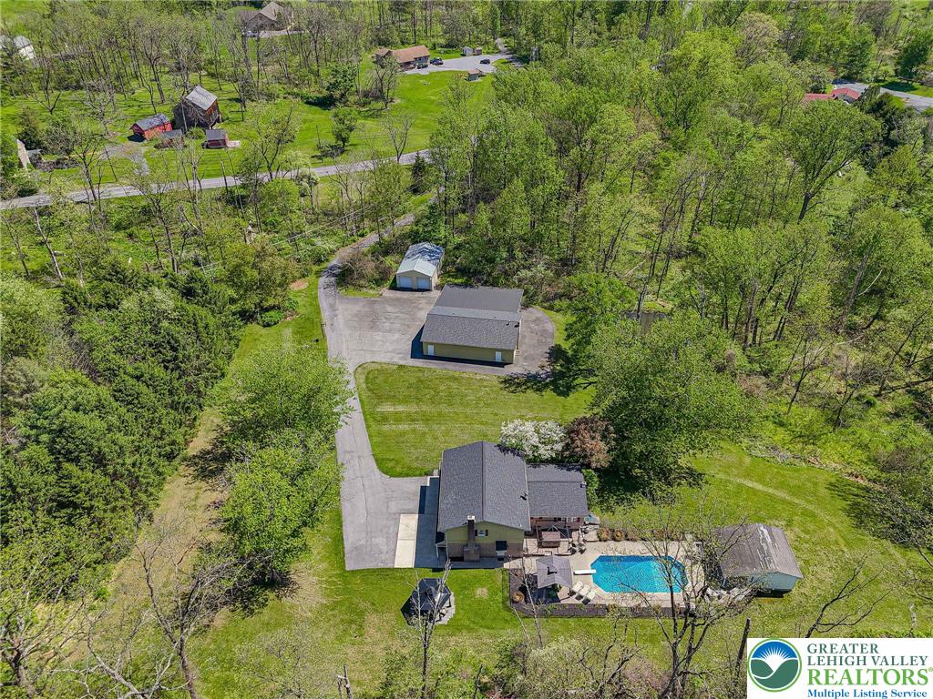 3857 Friedens Road Slatington, PA 18080 - Photo 5 of 75 An aerial view showcases a residence with an inviting outdoor pool and expansive green surroundings.