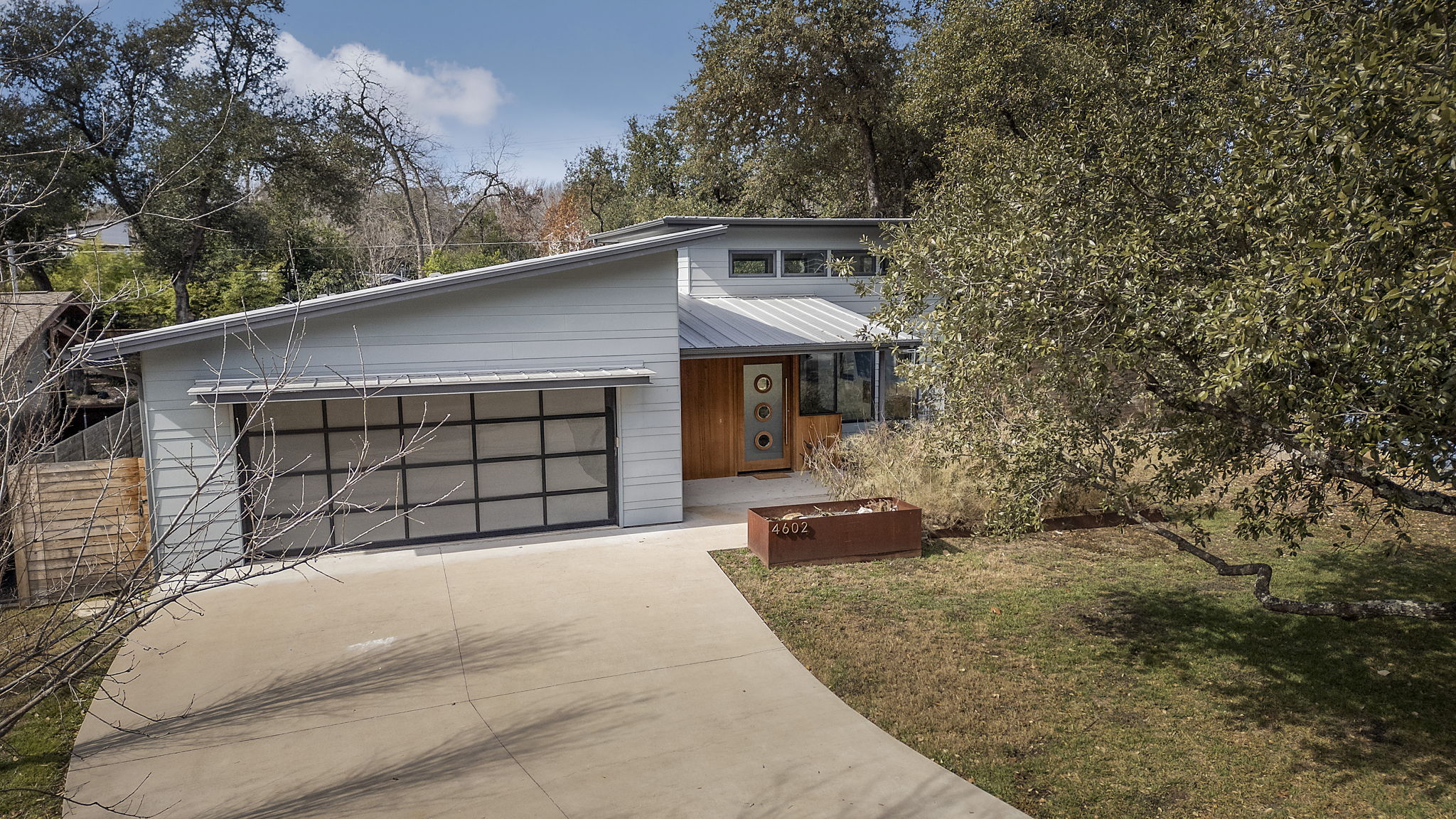 4602 Rue Street Austin, TX 78731 - Photo 1 of 1 View of front facade with concrete driveway, a front yard, and a metal roof